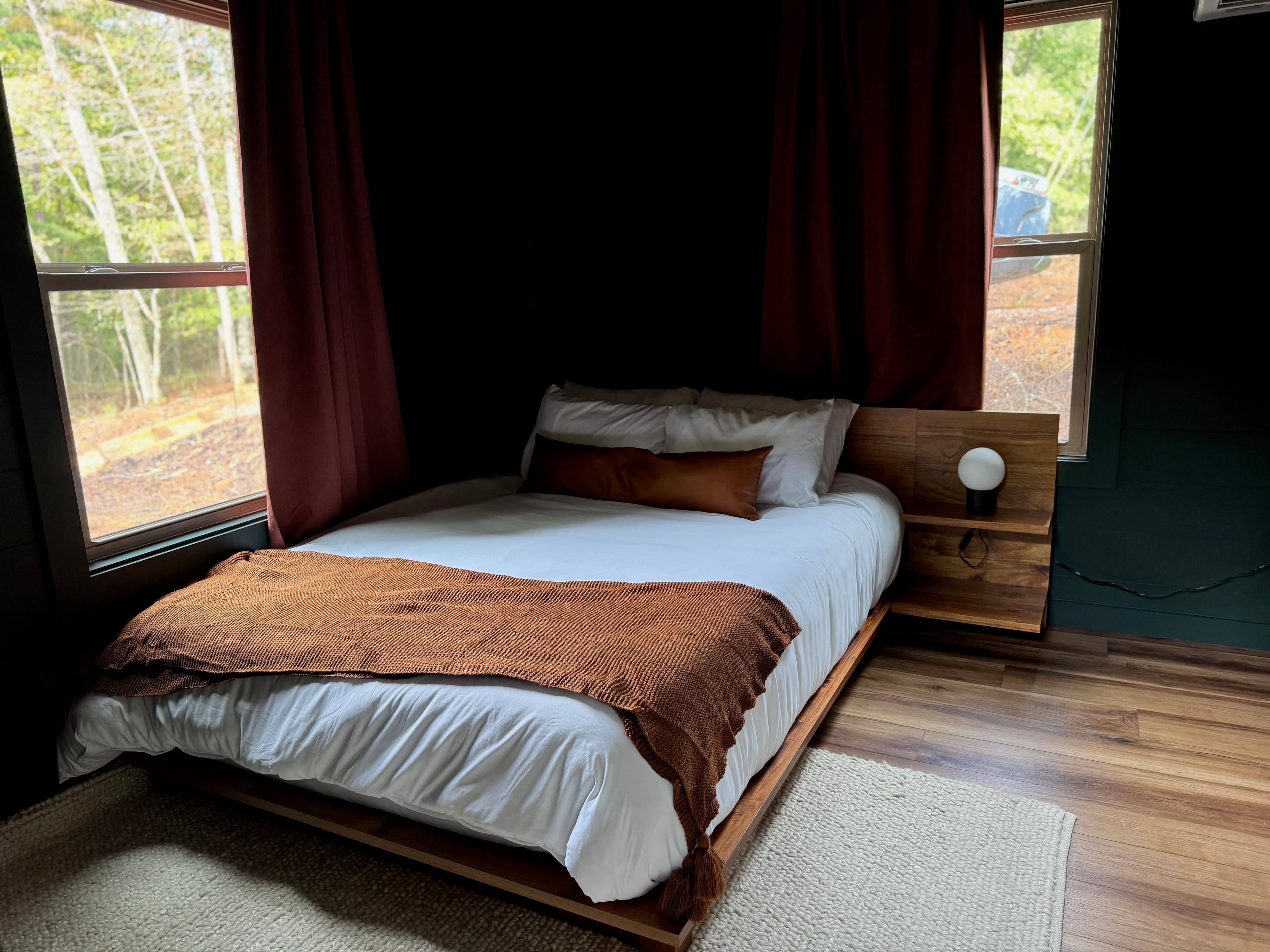 Bedroom with deep forest green walls and terracotta bedding
