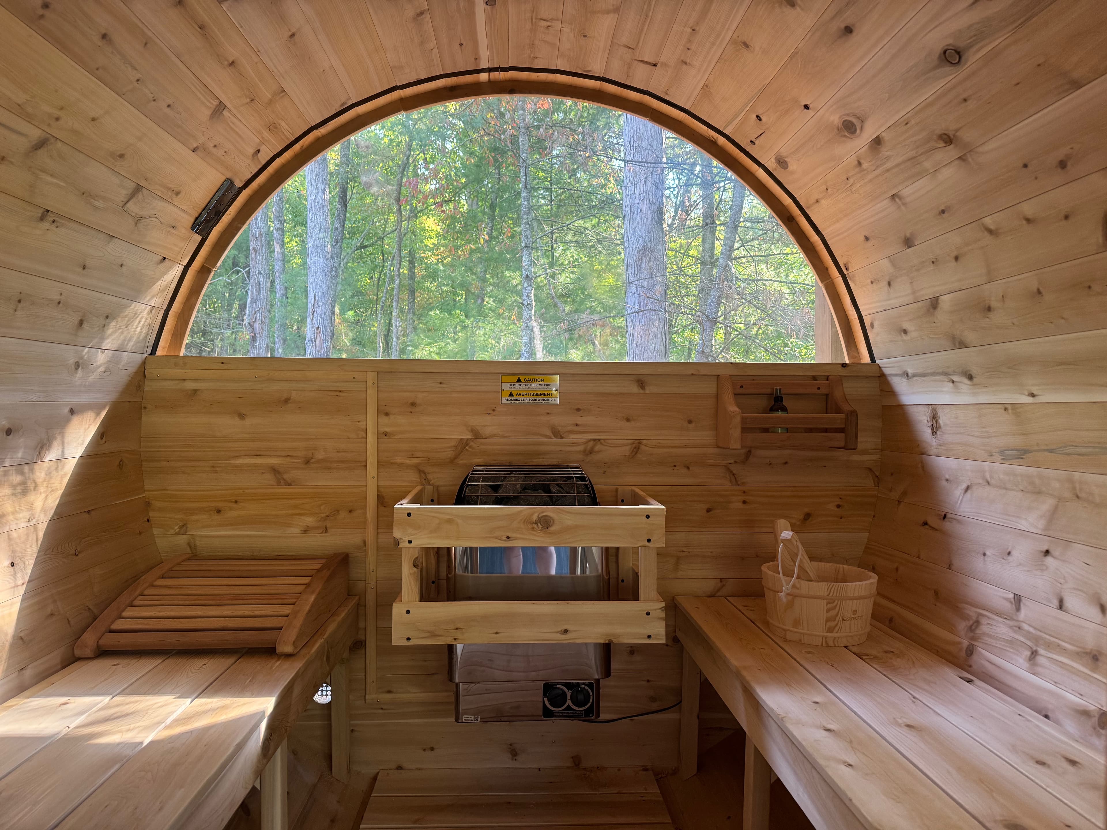 Inside the cedar sauna, arched window looking out to the forest