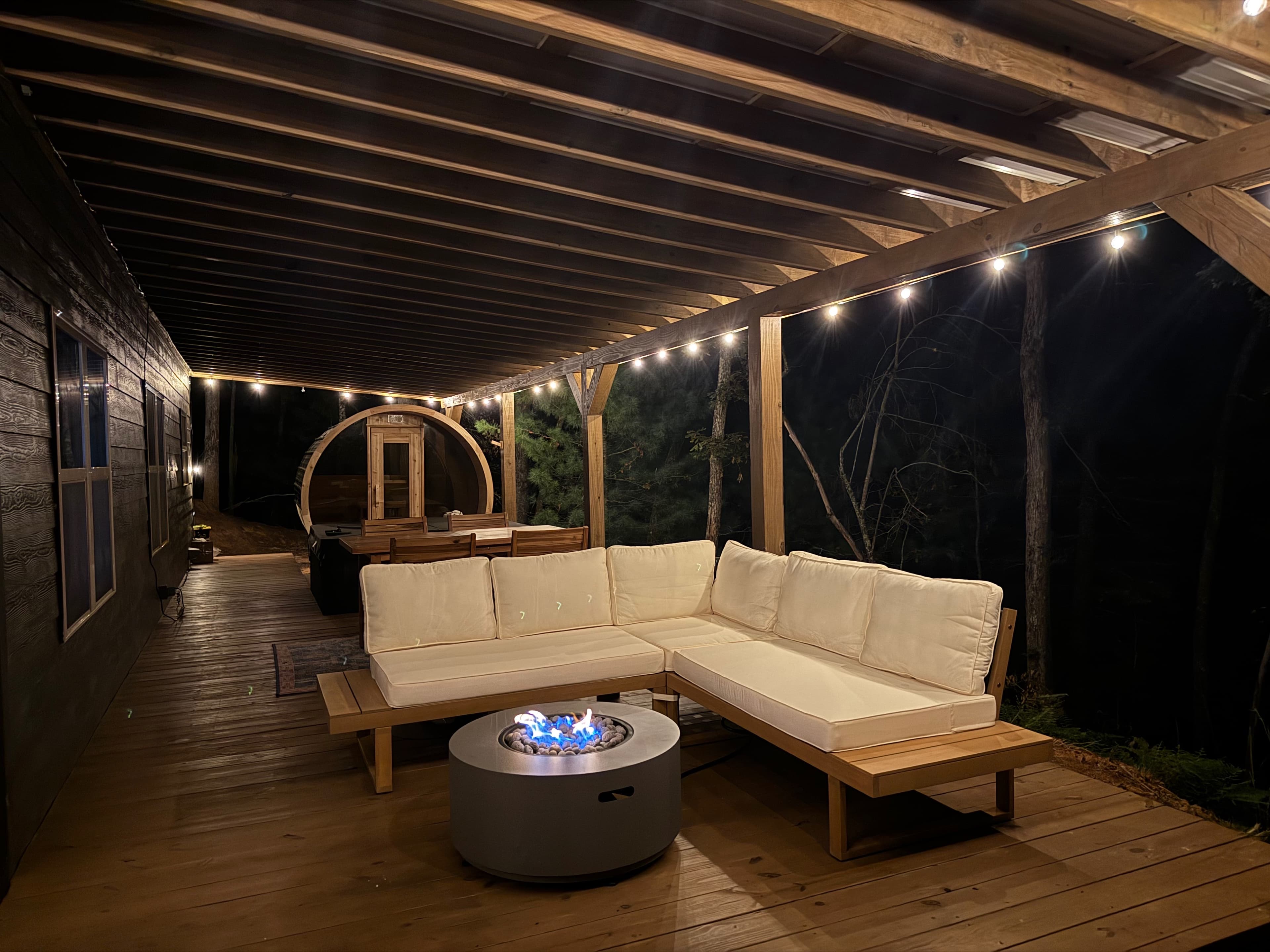 The pergola lounge with the fire pit lit at night