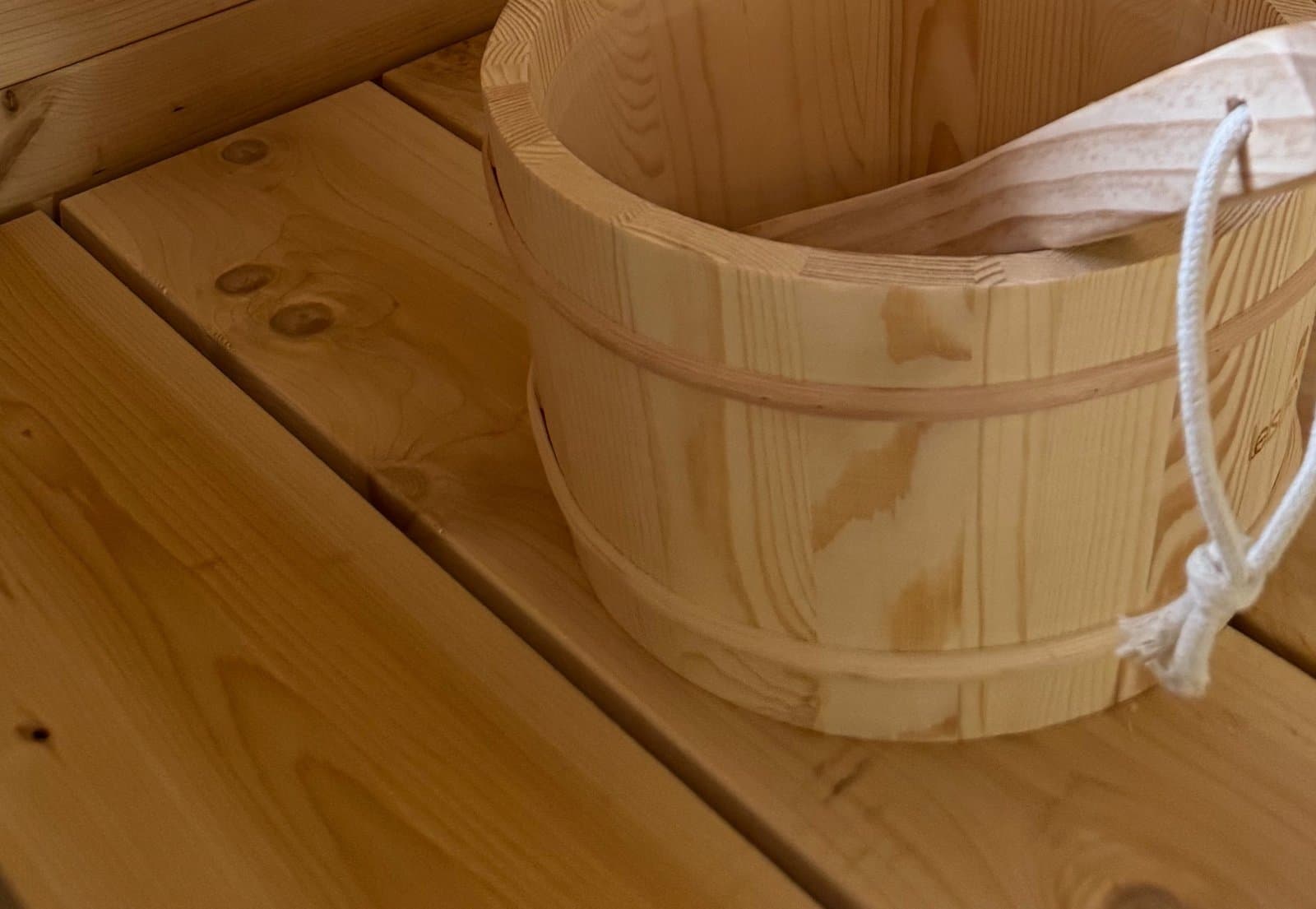 Wooden water bucket and ladle inside the sauna, for steam on the rocks